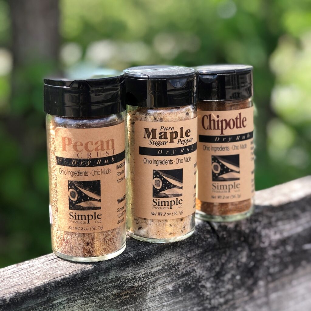 A photo of three shakers of dry rub seasoning. One is pecan, one is maple, and one is chipotle flavored. 