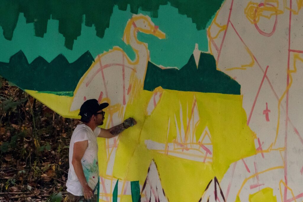 Arlin painting section of mural.