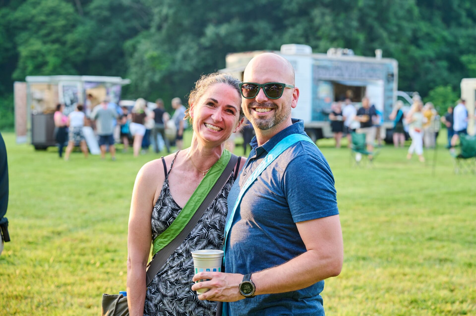 Couple standing in the foreground with food trucks and people at Elevation in the background.